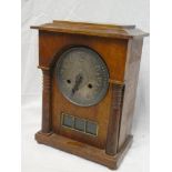 A 1930s Art Deco-style mantel clock with pewter circular dial in polished oak rectangular case