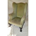 A 19th Century wing easychair upholstered in green fabric on carved mahogany cabriole legs