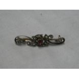 An old gold bar brooch set a central ruby surrounded by diamonds