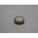 A 9ct gold dress ring with scroll mounts set five garnets