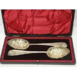 A pair of Victorian silver plated berry serving spoons with decorated bowls and handles in velvet