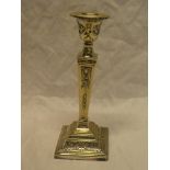 A good quality silver tapered candlestick with raised swag and scroll decoration on square shaped
