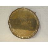 A George VI silver circular tray with pie-crust edge and engraved presentation text on claw and