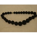 An ornate carved bog oak beadwork necklace