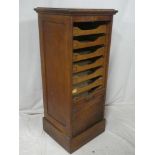 An old oak upright filing pedestal with sliding trays enclosed by a tambour shutter front