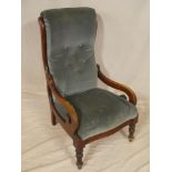 A Victorian mahogany open arm easy chair upholstered in blue buttoned fabric on turned tapered legs
