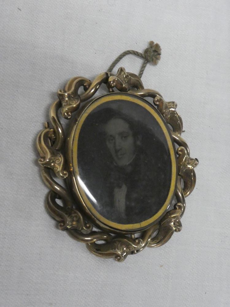 A Victorian pinchbeck oval mourning brooch with inset male bust portrait,