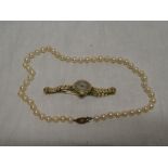 A cultured pearl necklace with 9ct gold clasp set garnets and a 9ct gold ladies wristwatch