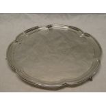 A George V silver circular salver with lobed edged on three tapered feet, Sheffield marks 1927,