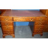 A polished mahogany rectangular pedestal desk with three drawers in the frieze and six pedestal
