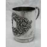 A late Victorian silver christening-style tankard with raised scroll decoration and scroll handle,