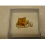A silver dress ring set rectangular citrine flanked by diamond chips