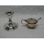 A small silver squat-shaped table candlestick with circular spreading base,