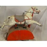 A vintage coin operated fibreglass ride-on horse on motorised base with coin mechanism,