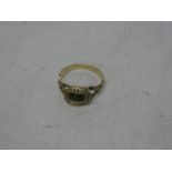 A Georgian gold dress ring with raised scroll decoration set red stone