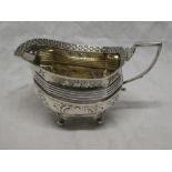 A George IV silver oval milk jug with floral and leaf decoration and decorated edge,