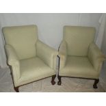 A pair of Edwardian mahogany easy chairs upholstered in green fabric on cabriole legs