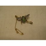 A good quality gold bar brooch in the form of a bee with peridot mounted body,