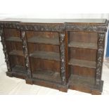 A Victorian carved oak break front bookcase with three open sections with adjustable shelves