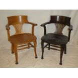 A pair of Edwardian oak office chairs with pierced splat backs and shaped seats on scroll-shaped
