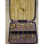 A set of six George V silver and enamelled coffee spoons with floral decorated terminals,