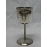 A small modern silver goblet with decorated stem and circular base,