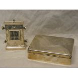 A silver rectangular card case with hinged lid,