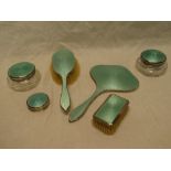 A George V silver and green enamelled dressing set comprising hand mirror, hairbrush, clothes brush,