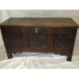 An 18th Century carved oak rectangular coffer with triple panelled front and hinged lid on block