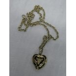 A 9ct gold mounted heart-shaped locket pendant with black enamel and floral decoration with 9ct