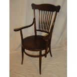 A late 19th Century stained beechwood spindle back open armchair with circular seat on tapered legs