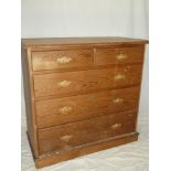 A late 19th Century pitch pine chest of two short and three long drawers with brass ring handles on