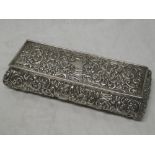 A late Victorian silver rectangular table box with raised scroll decoration and hinged lid,