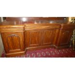 A mid Victorian mahogany breakfront side board with sliding trays and shelves enclosed by four