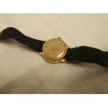 A ladies 9ct gold wristwatch by Omega with fabric strap and 9ct gold clasp