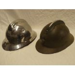 A French military painted steel helmet with raised comb and grenade badge and a French Fire Brigade