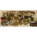 A selection of various cloth military badges, shoulder titles, divisional signs,