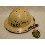 A post WWII National Hospitals Service Reserve painted steel helmet and cloth badge