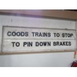 A wooden white painted lineside sign - GOODS TRAINS TO STOP TO PIN DOWN BRAKES,