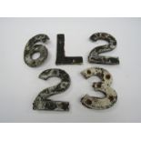 A quantity of cast alloy sleeper identification numbers and letters