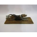 An early 20th Century cold painted bronze running hound desk paper clip on oak base