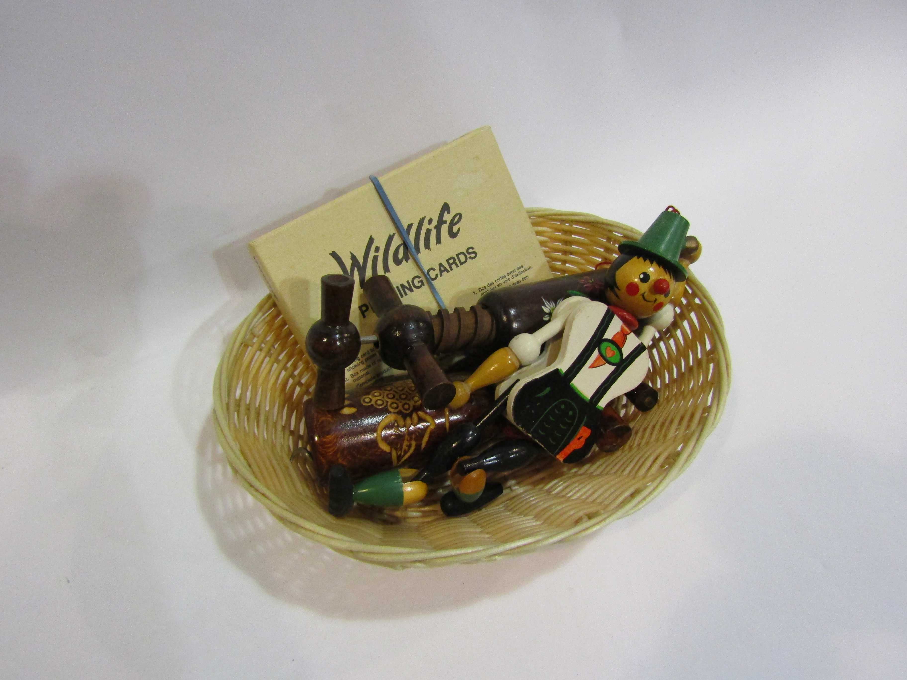 A basket containing Austrian playing cards, Swiss wooden corkscrews,