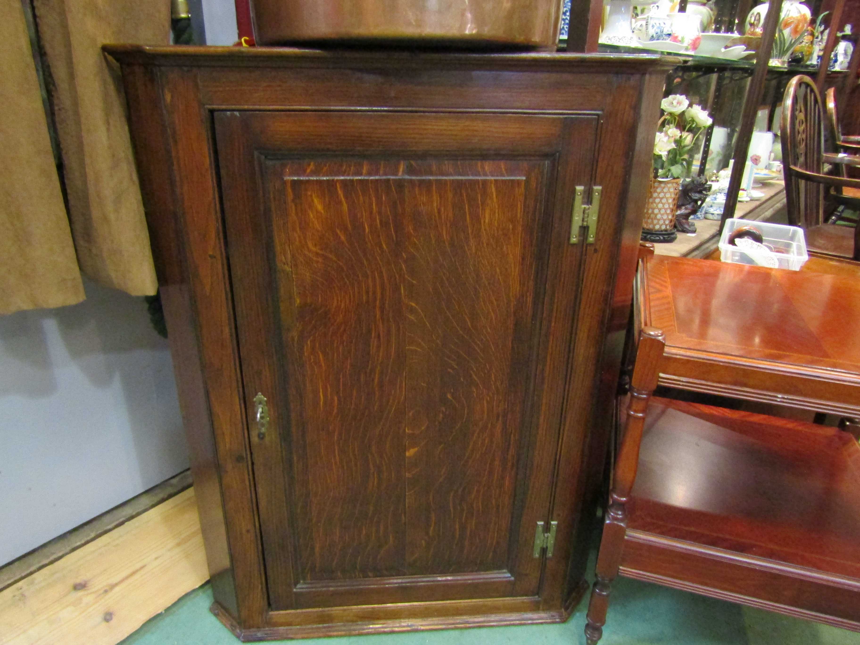 An oak single door wall hanging corner cupboard with painted interior and key,