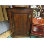 An oak single door wall hanging corner cupboard with painted interior and key,