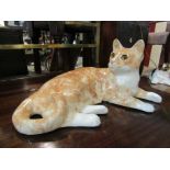 A Winstanley recumbent ginger cat, a/f,