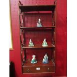 A wall hanging shelf with pierced sides and lower drawer,