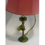 A brass table lamp with castellated top