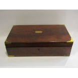A Victorian flame mahogany and brass bound writing slope containing inkwells and quills