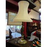 A heavy brass table lamp with shade