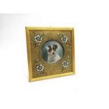 A Victorian enamel and ormolu frame with image of a Jack Russell, 12cm x 11.